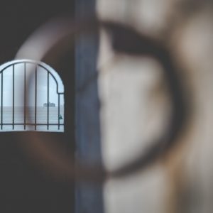 View through a metal ring down to the rusty bars of a window in the Hotwalls structure