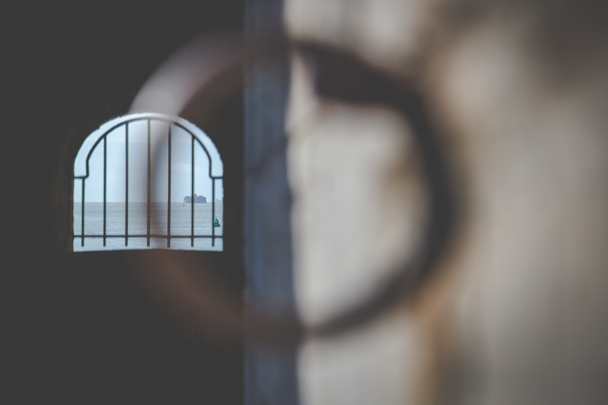 View through a metal ring down to the rusty bars of a window in the Hotwalls structure